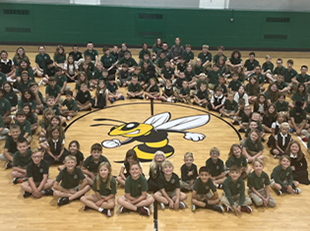 St. Helen School Students in Uniforms Sitting in Circle on Gym Floor